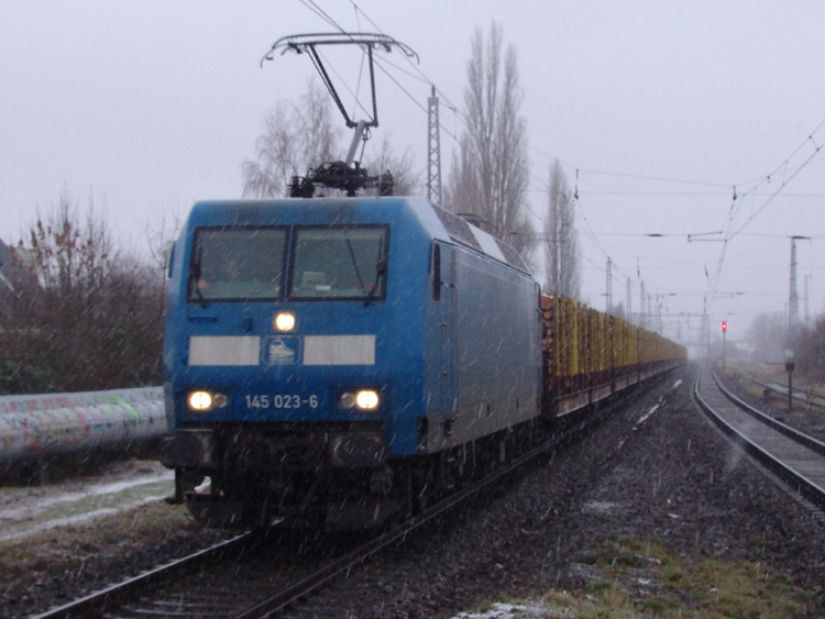 145 023-6 mit Holzzug von Rostock-Bramow Richtung Stendal-Niedergrne bei der Durchfahrt im S-Bahnhof Rostock-Holbeinplatz.(12.12.10)