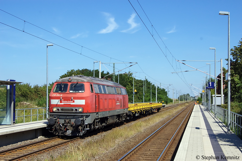 218 261-6 der Bahnbau Gruppe mit zwei Flachwagen am Haltepunkt Demker und fuhr in Richtung Magdeburg weiter. 22.08.2011
