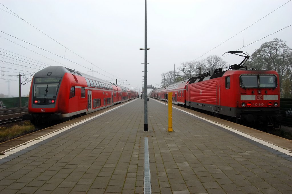 Links steht die RE2 (RE 38137) nach Knigs Wusterhausen gezogen von der 112 104-5 und rechts steht die 143 843-1 die den RB21 (RB 28011) nach Potsdam Griebnitzsee geschoben hat in Wustermark. 02.11.2010