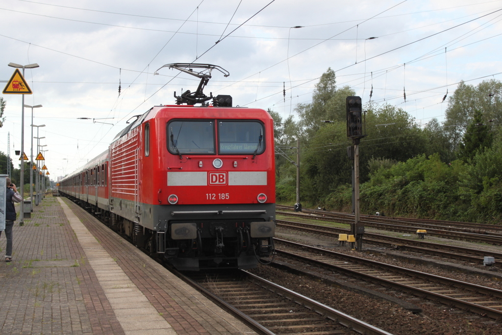 112 185 mit RE 13291 von Berlin-Gesundbrunnen nach Warnemünde bei der Durchfahrt am Abend des 04.08.2017 in Rostock-Bramow.