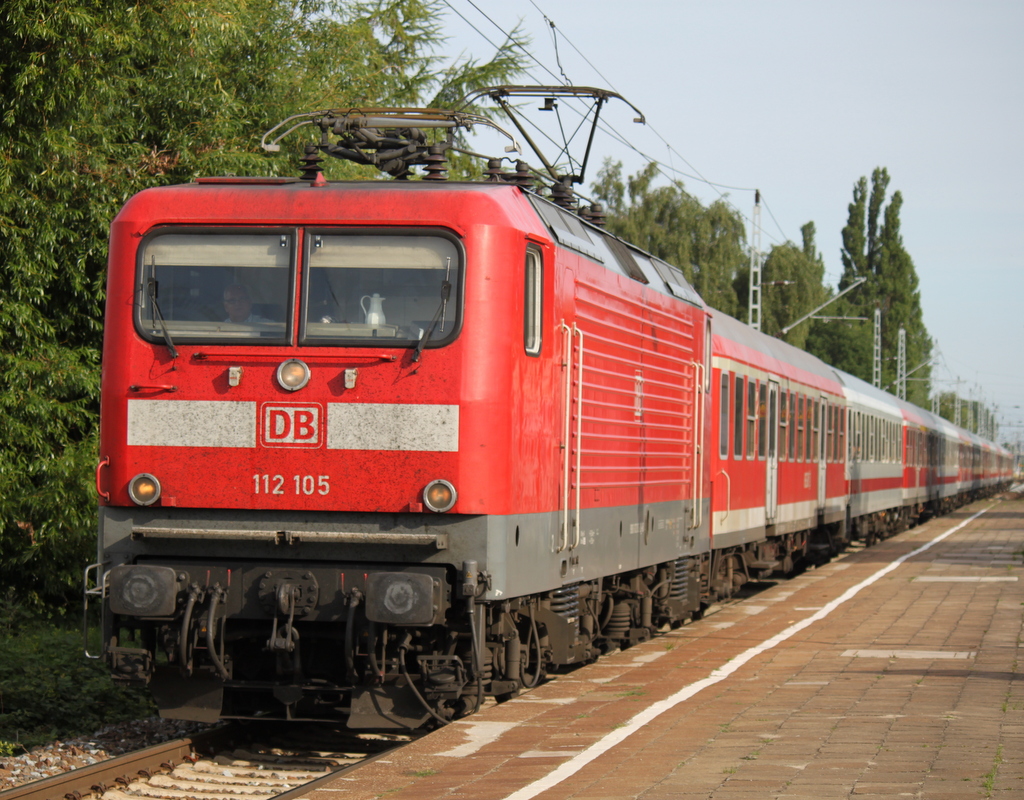 Die Rostocker 112 105-2 mit dem Pommes Rot-Wei Express 13290 von Warnemnde nach Berlin-Zoo bei der Durchfahrt am 28.05.2015 im Haltepunkt Rostock-Holbeinplatz.24.07.2015