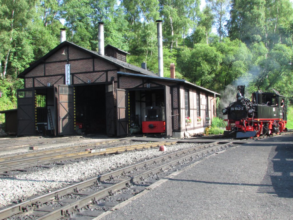 99 1542-2 kurz vor dem Ansetzen an ihren Zug am 13.Juli.2013 in Jhstadt.
Im Schuppen sind 99 715 und 99 4511 und eine Diesellok