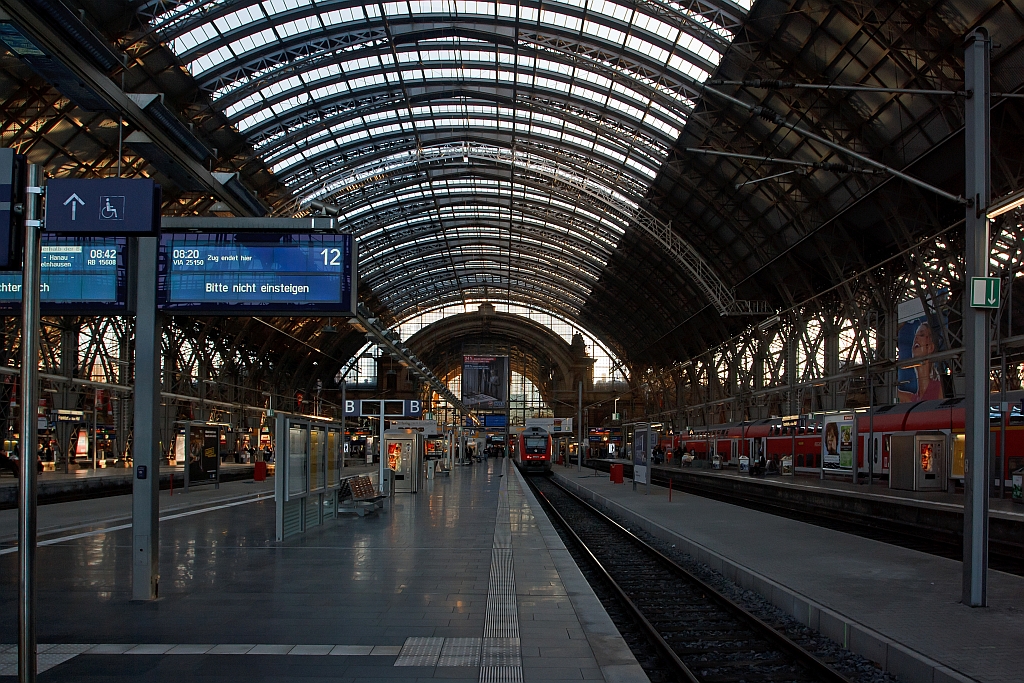 Blick vom Bahnsteig 12 in eine der fnf Bahnsteighallen des Hbf Frankfurt am Main am 30.09.2011.
Von 2002 bis 2006 wurden die seit 1972 unter Denkmalschutz stehenden Dcher der fnf Bahnsteighallen im laufenden Betrieb unter Bercksichtigung denkmalpflegerischer Aspekte komplett erneuert. Insgesamt wurden etwa 60.000 Quadratmeter Dach- und Wandverkleidung – davon etwa 30.000 Quadratmeter Glasflche – erneuert und 5000 Tonnen Stahl ausgetauscht.