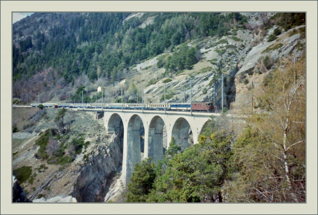 BLS Re 4/4 mit einem Schnellzug auf dem Luogelkin Viadukt bei Hohtenn. 
Scan/ Fr�hling 1993