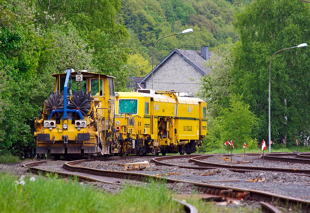 Deutsche Plasser Schotterverteil- und Planiermaschine SSP 110 SW (Schweres Nebenfahrzeug Nr. 97 16 40 549 18 - 6)  und dahinter die Plasser & Theurer Universalstopfmaschine 08 - 275 Unimat 3S Y (Schweres Nebenfahrzeug Nr. 97 43 41 523 17 - 9) der DGU (Deutsche Gleisbau Union), abgestellt am 14.05.2013 in Herdorf auf der Gleisanlage der KSW (Kreisbahn Siegen-Wittgenstein).

Der Schotterpflug wurde 1995 unter der Masch.-Nr. 607  bei der Deutsche Plasser gebaut. Die  Stopfmaschine wurde 2001 unter der Masch.-Nr. 1172 bei Plasser & Theurer in sterreich gebaut.