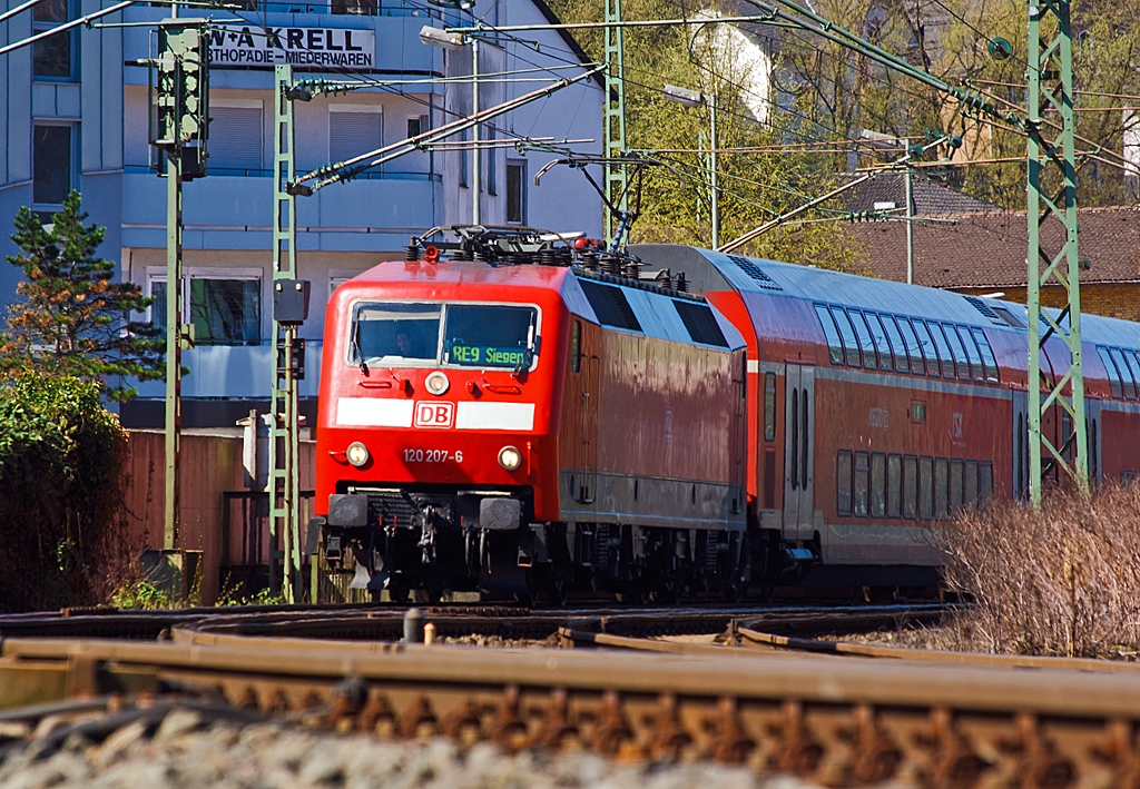 Die 120 207-6 (ex 120 136-7) zieht den RE 9 - Rhein Sieg Express (RSX) Aachen - Kln - Siegen am 20.04.2013 nun vom Bahnhofes Betzdorf/Sieg weiter in Richtung Siegen.

Die Baureihe 120.2 bildet mit je fnf neuen Doppelstockwagen jeweils einen Wendezug wegen der erhhten fahrdynamischen Werte (fnf statt bisher vier Wagen) wurden hierfr im Jahre 2007 erstmals fnf Loks dieser Baureihe mit einem Nahverkehrspaket (Zugzielanzeiger, Zugabfertigungssystem, Server u. a.) ausgerstet und in die Baureihe 120.2 mit neuer, fortlaufender Ordnungsnummer (201 bis 205) eingereiht, diese sind in Rostock beheimatet fr den Hanse-Express. Mit maximal 160 km/h befahren sie die Strecken.

Ende 2010 wurden weitere drei Maschinen mit den neuen Ordnungsnummern 120 206 bis 208 (ehemals 120 136, 139, 117) an DB Regio Rheinland abgegeben. Sie werden in Nordrhein-Westfalen auf dem Rhein-Sieg-Express eingesetzt, mittlerweile durch DB Regio NRW. Diese bilden mit je sechs neuen Doppelstockwagen einen Wendezug (anstatt bisher fnf Wagen).
