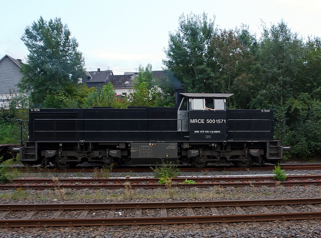 Die MRCE 500 1517 (275 625-2), eine Vossloh G 1206, mit leeren Sammnps Flachwagen (6-achsig) Ganzzug, fährt, am 23.08.2011, von Herdorf weiter Richtung Betzdorf. Die Lok wurde 2006 von Vossloh unter Fabriknummer 5001571 gebaut. 