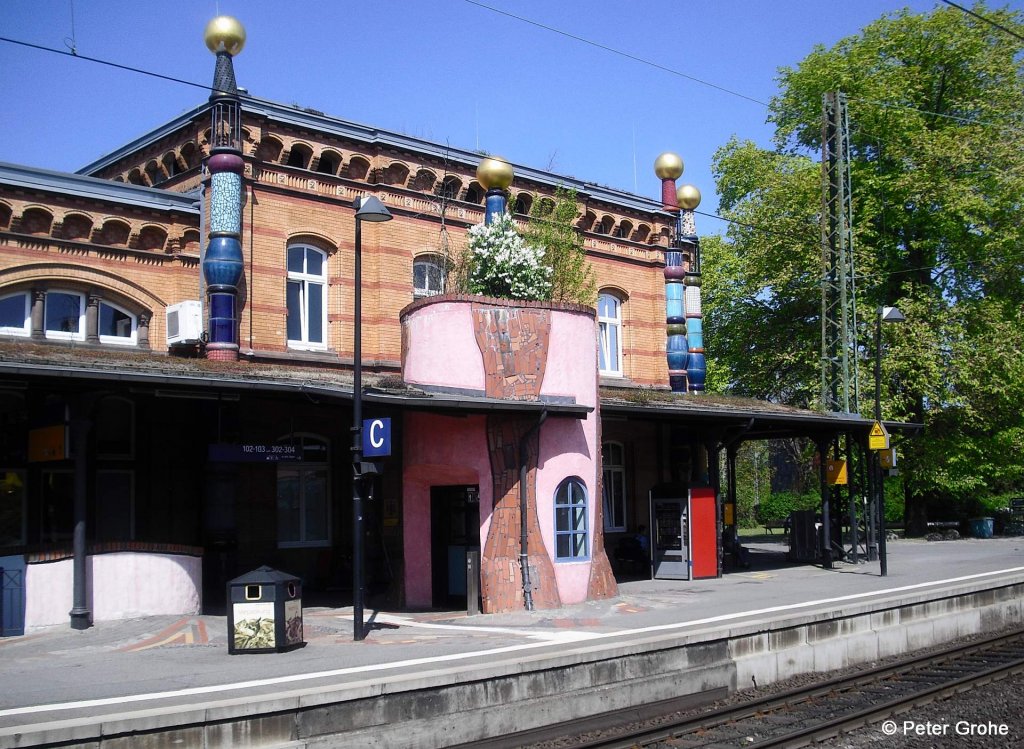 Gleisseite vom Empfangsgebude Bahnhof Uelzen --> Der Bahnhof wurde vom sterreichischen Knstler Hundertwasser entworfen und von 1999 bis 2001 zum   Kulturbahnhof   umgebaut. Es gibt dort viele sehenswerte Details wie z.B. das Trmchen in der Mitte: = Liftschacht mit Dachgarten!
fotografiert am 06.05.2011