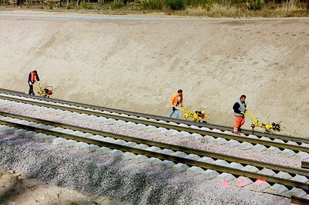 ICE Neubaustrecke Köln Frankfurt während der Bauphase. Gleisbauarbeiten am Streckengleis vom Flughafenbahnhof Köln/Bonn in Richtung Köln Hbf kurz hinter dem Tunnel, der am Mauspfad endet. Die Aufnahme stammt vom 21.03.2003.