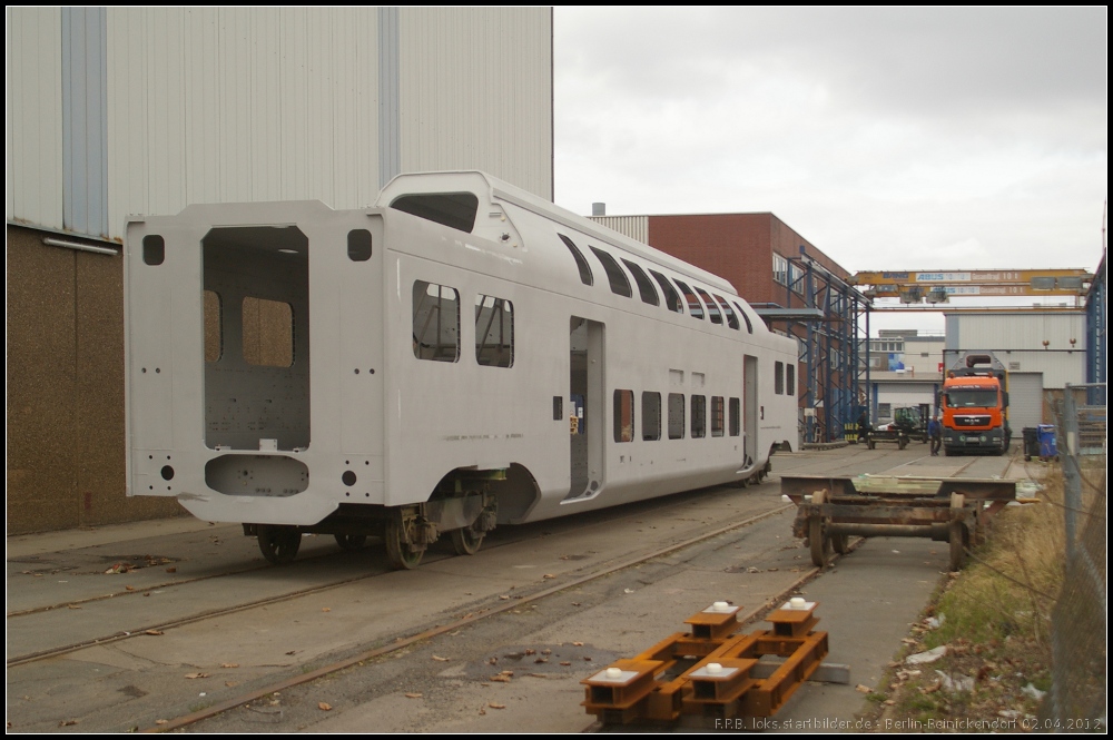 Rohbau eines KISS f�r die ODEG. Der Wagen wird auf Hilfsdrehgestellen noch in die Lackierhalle gebracht. Auf dem Tieflader rechts steht bereits ein lackierter Wagen um zur Endfertigung nach Bln.-Pankow gebracht zu werden (gesehen Berlin-Reinickendorf 02.04.2012)