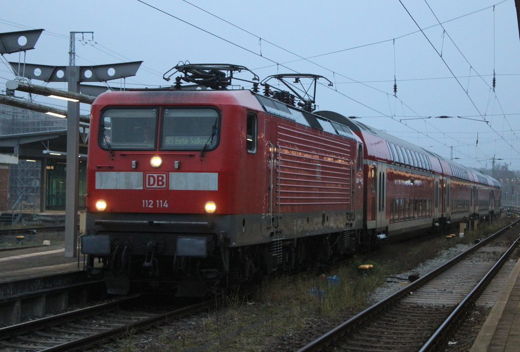 112 114 mit RE 5 von Rostock Hbf nach Berlin-Südkreuz bei der Ausfahrt im Rostocker Hbf.21.12.2025