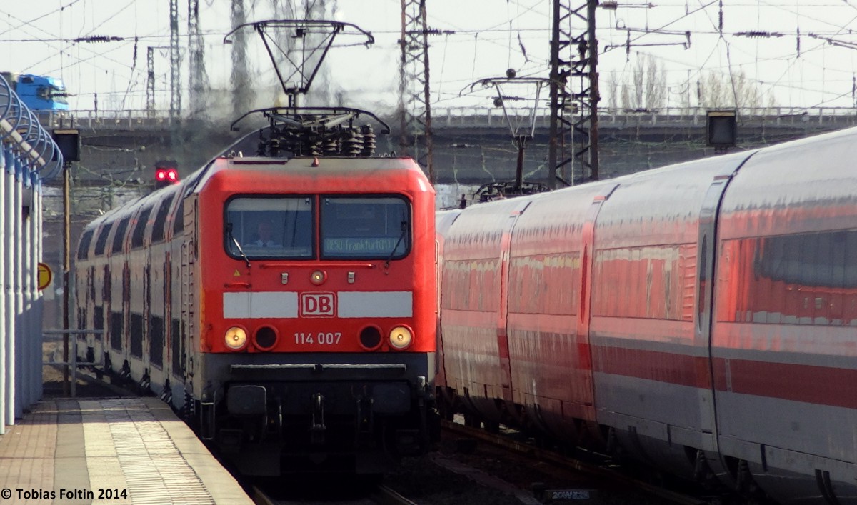114-007 zieht ihren RE in den Bahnhof von Hanau, als ihr ein ICE entgegen kommt.
Aufgenommen im März 2014.