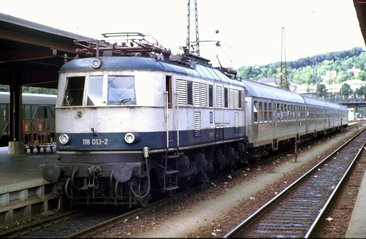 118 013-2 mit Silberlingen in Ulm, wahrscheinlich nach Regensburg am 24.07.1983. Selten war die Ausfahrt von Gleis 4 und nicht von den  bayerischen Gleisen  21 bis 25.