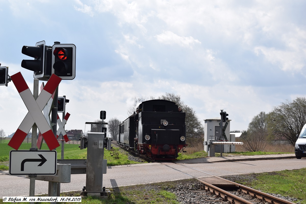 14.04.2018: Der Amateurlokführerzug am durch moderne Halbschranken gesicherten Bahnübergang zwischen Thondorf und Siersleben.