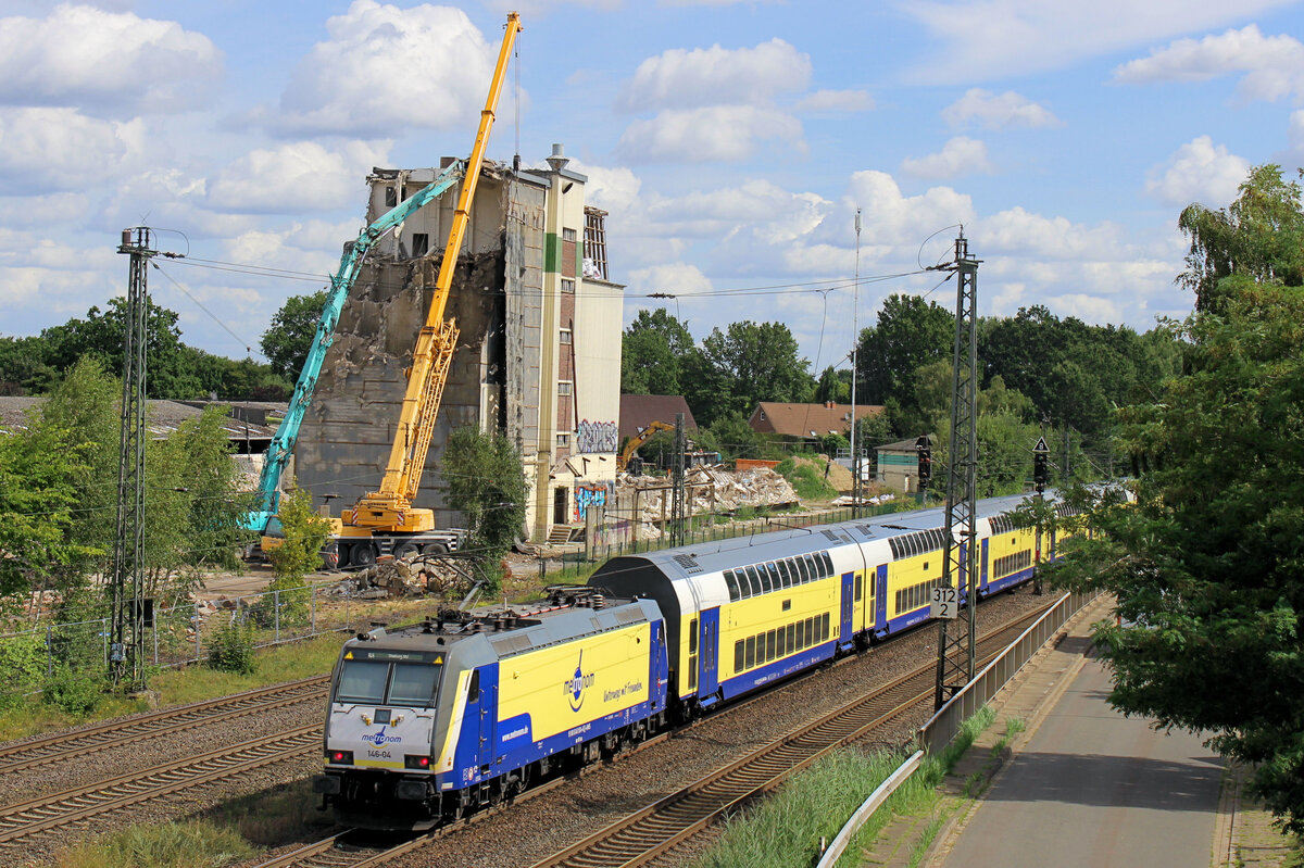 146 -04 verl�sst den Bahnhof Tostedt. Im Hintergrund: die Abrissarbeiten der alten Siloanlagen, die alten Lagerhallen links und rechts vom Silo sind schon  platt ! Datum: 06.08.2026