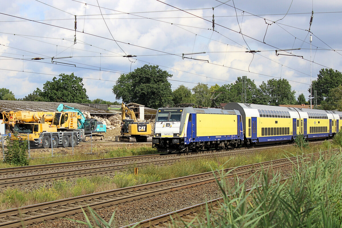 146 521 f�hrt am 21.08.2026 in den Bahnhof Tostedt ein. Im Hintergrund sind die Aufr�umarbeiten des abgerissenen Getreidesilos zu sehen.
