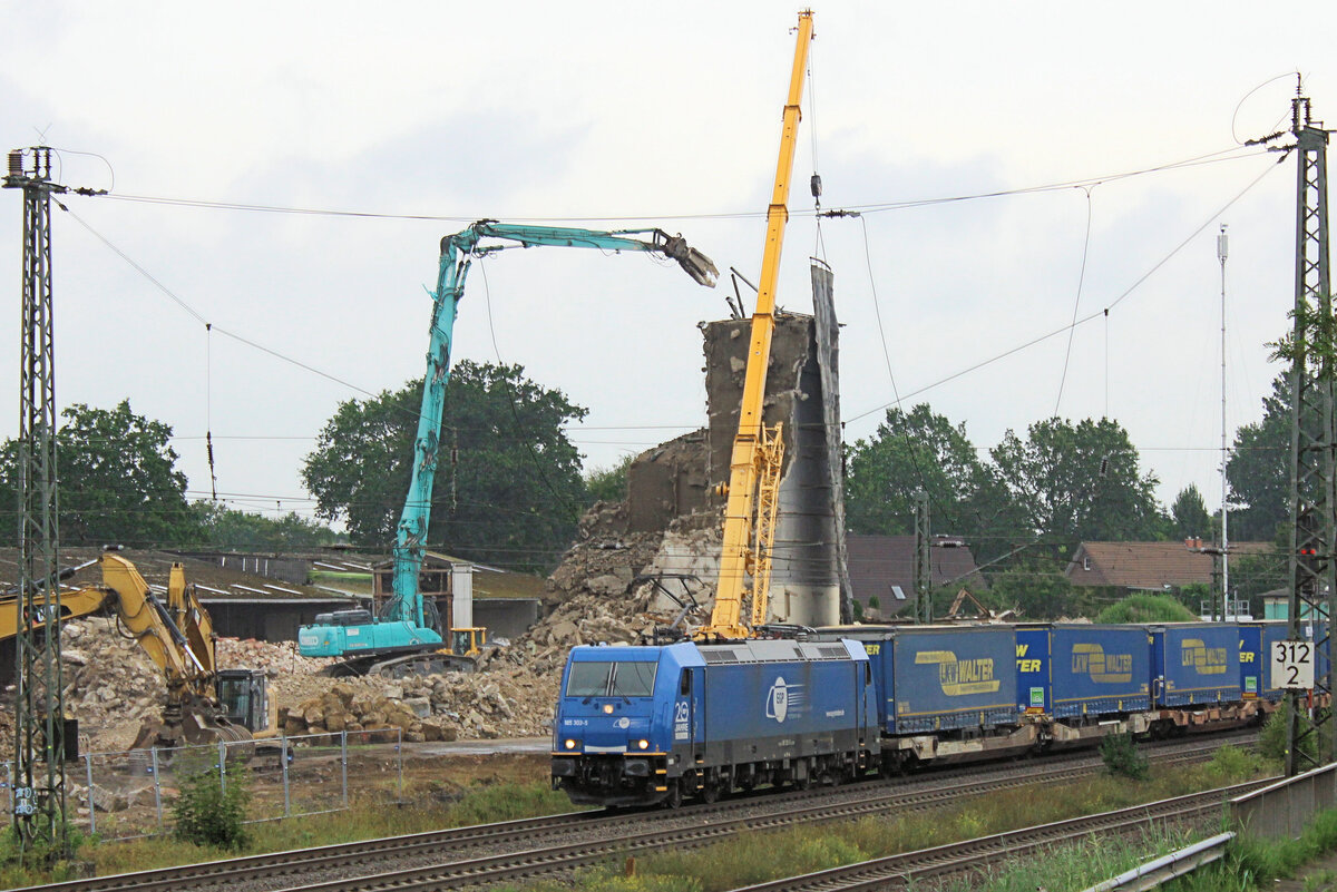 185 303-5 EGP durchf�hrt mit einen  LKW-Walter  Tostedt. Im Hintergrund: Abrissarbeiten am Vormittag des 19.08.2026.