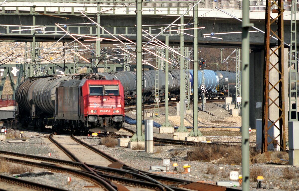 185 340-7 von Rhein Cargo mit Werbung und Kesselwagenganzzug in Ulm am 09.02.2023.