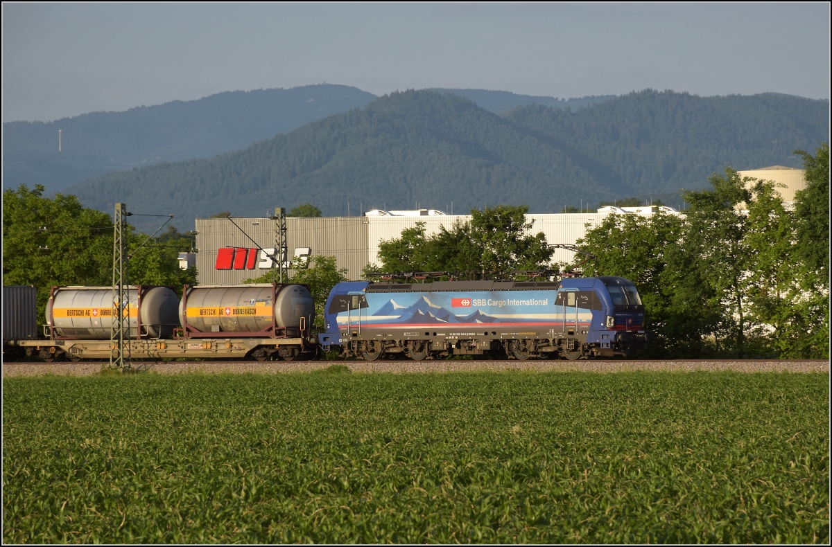 193 520 der SBB Cargo international südwärts im Abendlicht bei Buggingen. Juni 2022.