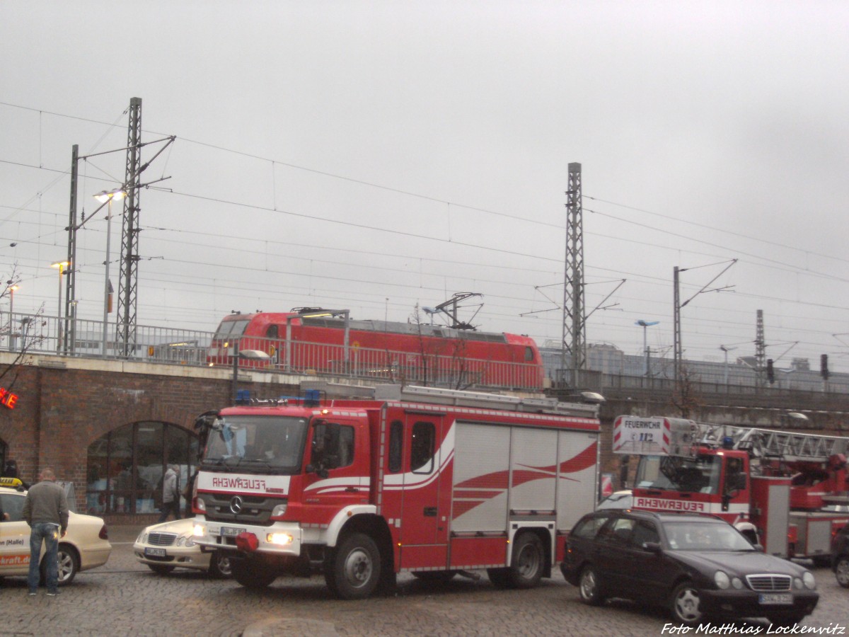 2 rote Fahrzeuge - BR 185 mit einem G�terzug und ein FeuerwehrFahrzeug beim Einsatz am Hallenser Hauptbahnhof am Morgen des 19.11.14