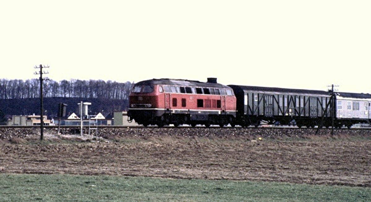 210 005-5 mit Nahverkehrszug bestehend aus Behelfspackwagen und Silberlingen in Illertissen im Mai 1980.