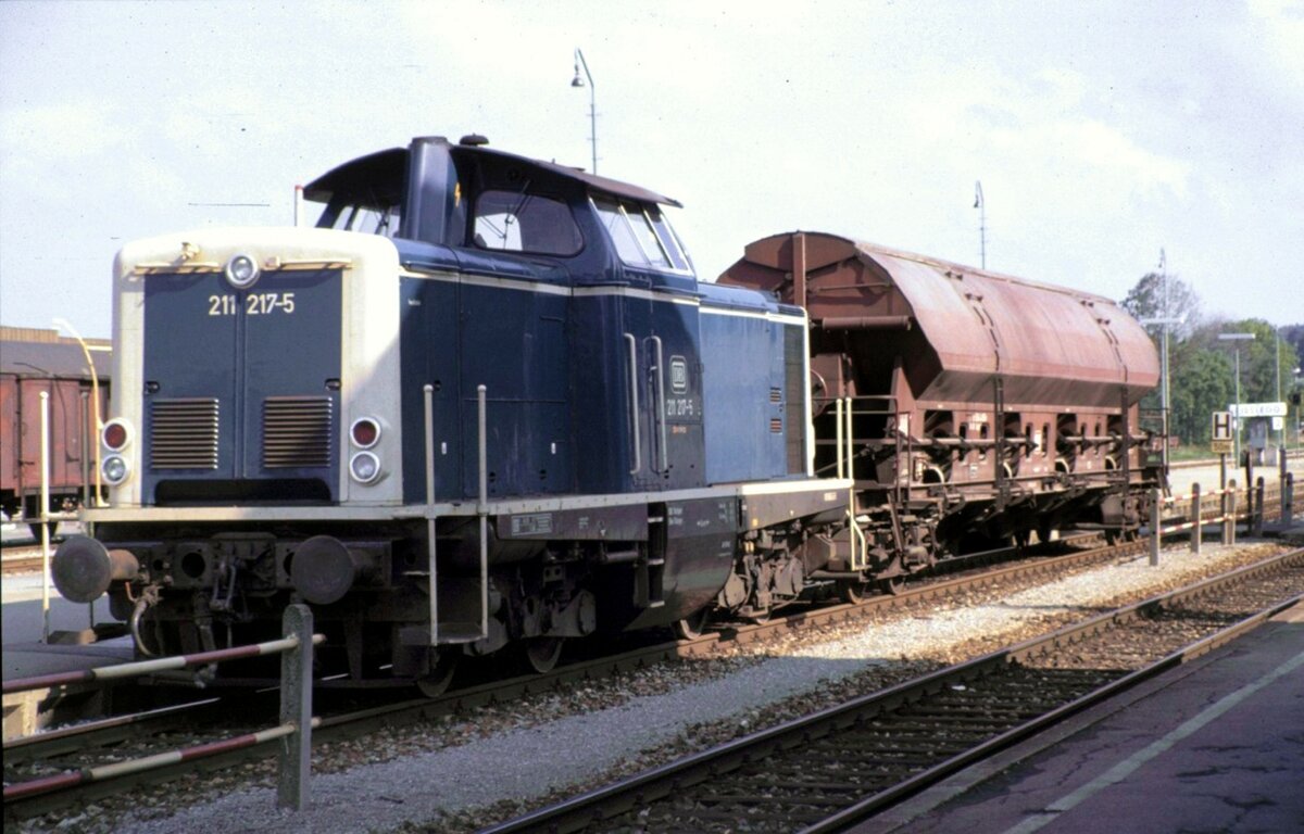211 217-5 mit Seitenentladewagen Typ Faes 105 von Fa. Talbot in Kißlegg am 02.10.1982.