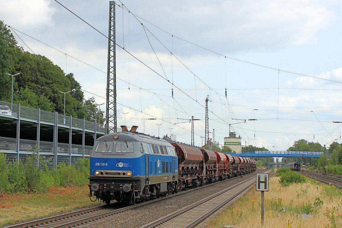 218 153-5 mit Schotterwagen am Haken, durchfährt am 30.06.2023 den Tostedter Bahnhof.