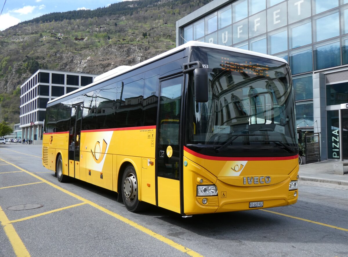 (274'013) - PostAuto Wallis - VS 445'902/PID 10'453 - Iveco am 14. April 2025 beim Bahnhof Sion