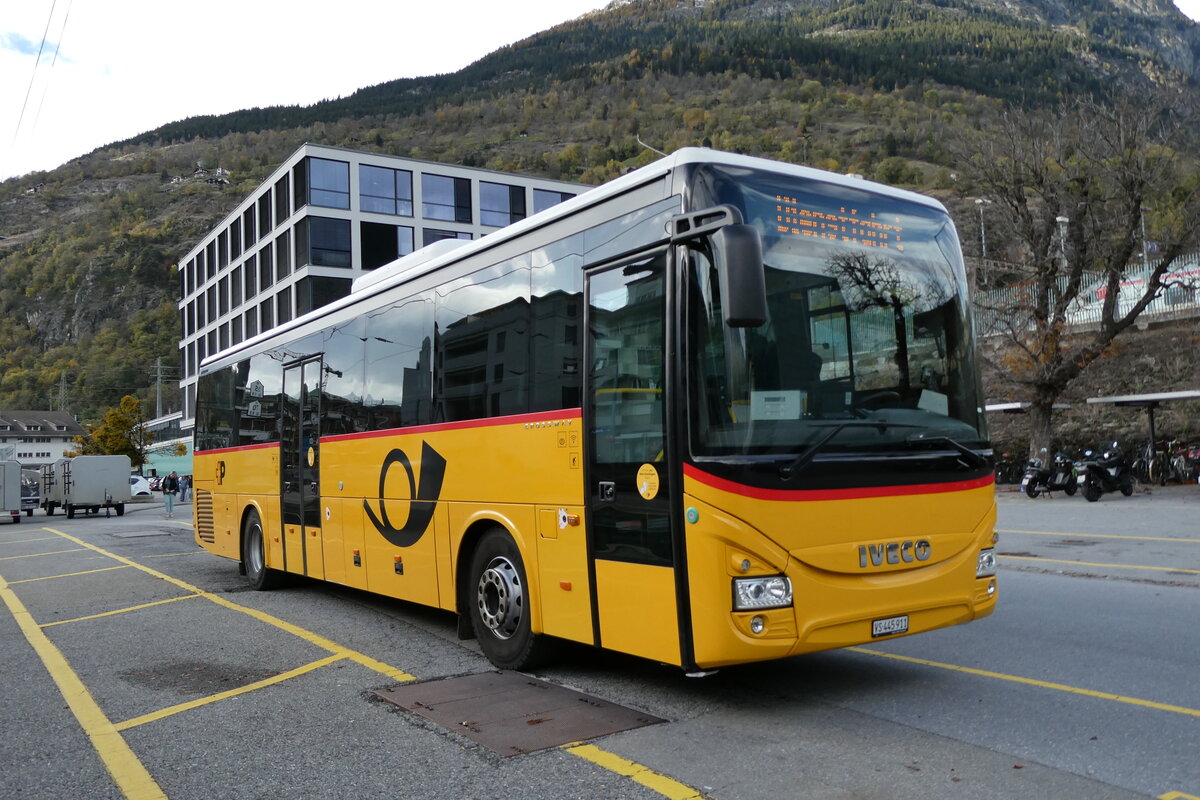(281'782) - PostAuto Wallis - VS 445'911/PID 10'521 - Iveco am 24. Oktober 2025 beim Bahnhof Brig
