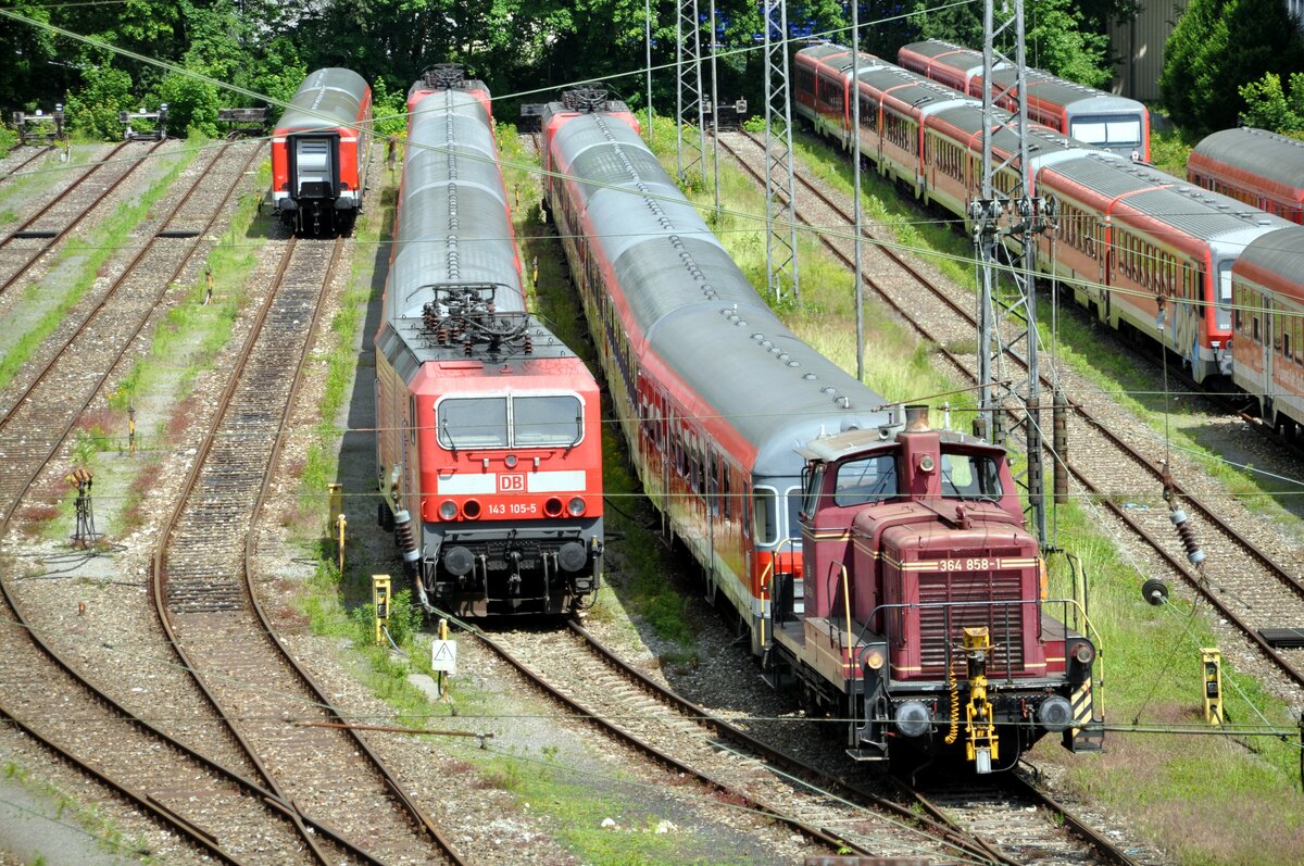 364 858-1 stellt einen Nahverkehrszug mit 143 am anderen Ende in Ulm bereit. Daneben steht ein weiterer Nahverkehrszug mit 143 105-5 und einer weiteren 143 im Sandwich. Auf den rechten Gleisen stehen mehrere 628er. Ulm am 09.06.2012.