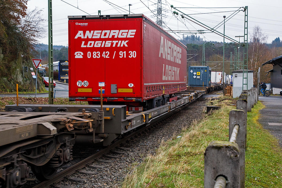 Achtachsiger niedrig gelegte Doppelwagen Jumbo II / Mega II (Trag-/Taschenwagen-Doppeleinheit) der Gattung Sdggmrrss, 83 85 4933 045-5 CH-HUPAC, der Hupac Intermodal SA, am 15.01.2022 im Zugverband bei einer Zugdurchfahrt in Scheuerfeld (Sieg). Diese Wageneinheiten bestehen aus einer niedrigen Taschenwagenhlfte („SK“) und einer niedrigen Tragwagenhlfte fr Container und Wechselbehlter („CT“). Die beiden Wagenhlften sind mit einer, im Normalbetrieb nicht zu trennenden, (von den Waggons der RoLa, Saadkms 690, abgeleiteten) Kurzkupplung verbunden.

Der niedrig gelegte Doppelwagen Mega II ist fast 37 Meter lang. Er wurde 2003 eingefhrt und ist heute auf allen Shuttle Net-Relationen der HUPAC im Einsatz. Der Mega-Wagen ermglicht den Transport von Standard- und Megatrailern mit einer verfgbaren Innenhhe von 2,55 bis 3,0 Metern je nach Streckenprofil. Durch die niedrig gelegte Ladeflche knnen C 70-400 kodifizierte Jumbo-Wechselbehlter bis Norditalien und High-Cube-Container bis Sditalien auf der Gotthardstrecke transportiert werden.

Zustzlich der Eignung fr die neuen Megatrailer, wegen deren Umschlagtechnik mittels tiefliegenden Greifkantenbeschlgen ein sehr niedrig aufbauender Wagenrahmen erforderlich ist, sollten auch Container und Wechselbehlter mit groen Hhenmassen alpenquerend befrdert werden knnen. Damit war ein ber die Ladelnge nicht in der Hhe gekrpfter Wagenrahmen erforderlich. Die verglichen mit der „Standardhhe“ von 1.175 mm ber Schienenoberkante (SOK), sehr niedrige Aufstandshhe von nur 855 mm des MEGA II machte den Einsatz von Drehgestellen der Bauart Y31 Lsi(f) notwendig. Diese weisen eine geringere Bauhhe, durch kleinere Radstze mit 760 mm Laufkreisdurchmesser und maximal 18 t Radsatzlast, auf.

Hersteller dieser Wagen ist die Ferriere Cattaneo in Giubiasco (Schweiz), die 115 Wagen (230 Wagenmodule) hergestellt hat. 