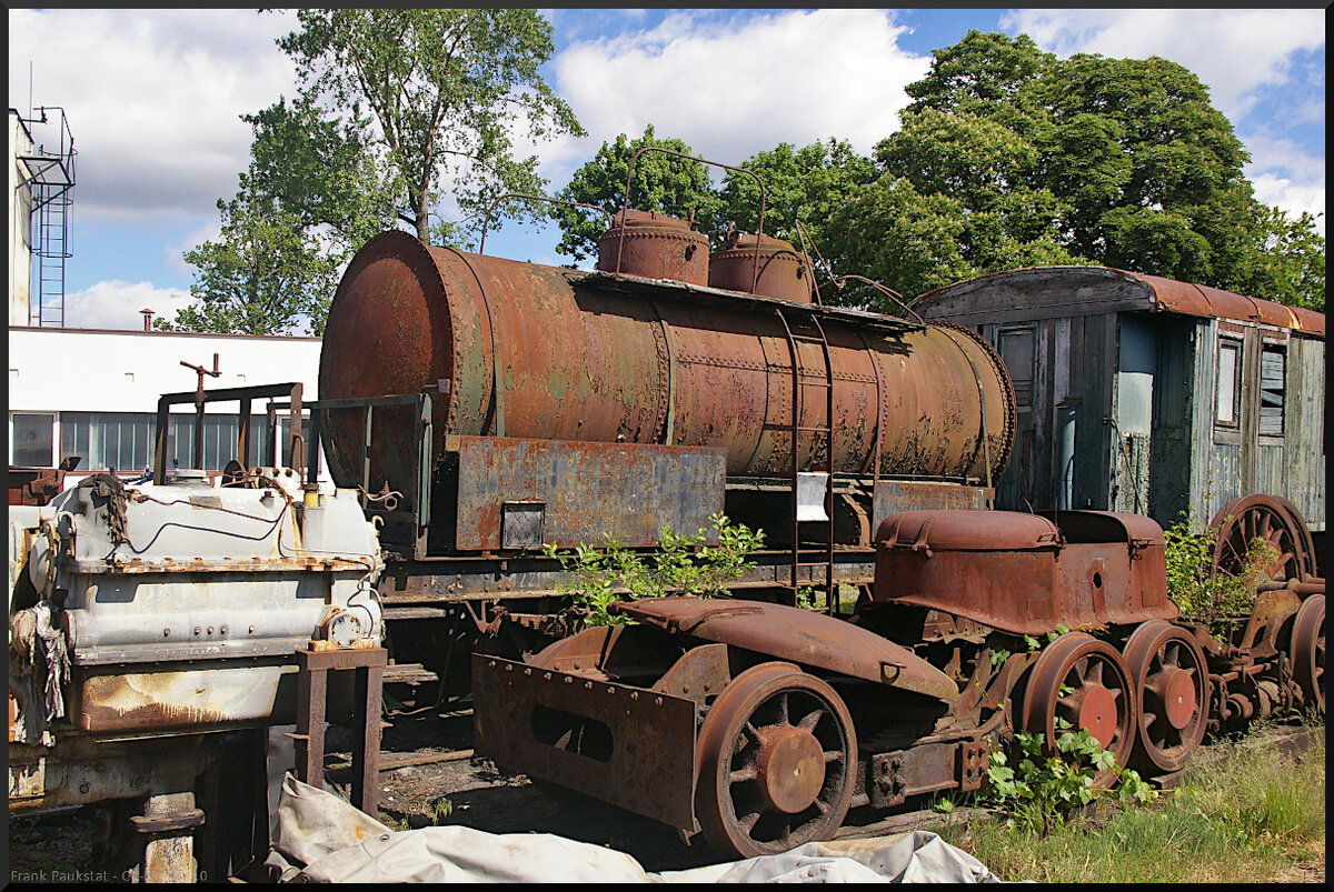 Am Eingang zum Eisenbahnmuseum Jaroměř finden sich auch einige alte Wagen, die als Erstteilager dienen oder wegen Geldmangels nicht aufgearbeitet werden können. Auf dem hinteren Gleis steht ein Kesselwagen mit zwei Klappen, der linke Wagen kippt tatsächlich nach rechts unten. Im Vordergrubnd ist links ein Motorblock zu sehen und in der Mitte wohl Drehgestelle und darauf eine Domabdeckung? Das alles und mehr gesehen am 21.05.2022.