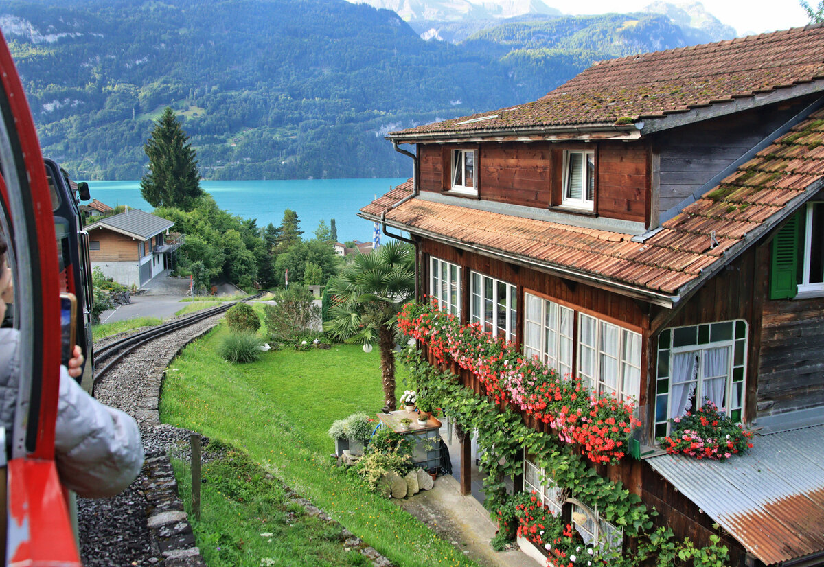 An einem wunderschön mit Geranien geschmückten Haus vorbei im Aufstieg mit Lok 11 Richtung Planalp. 3.August 2023 