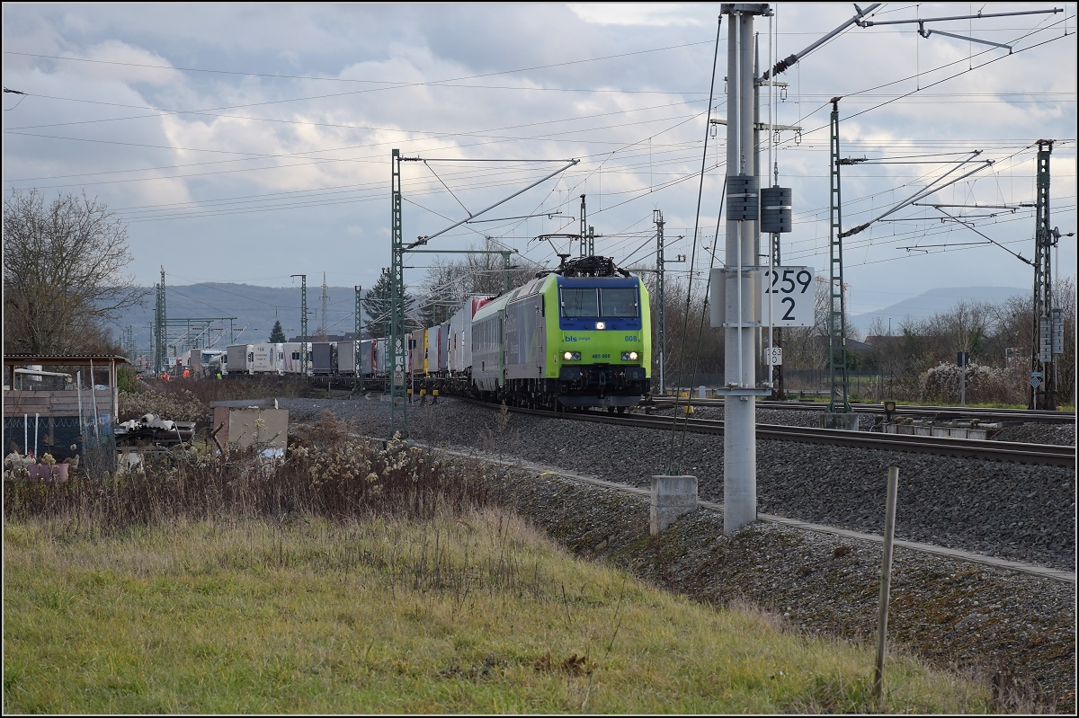 An der südlichen Ausfädelung in den Katzenbergtunnels fährt Re 485 008 mit einer RoLa Richtung Freiburg. Binzen, Dezember 2017. 