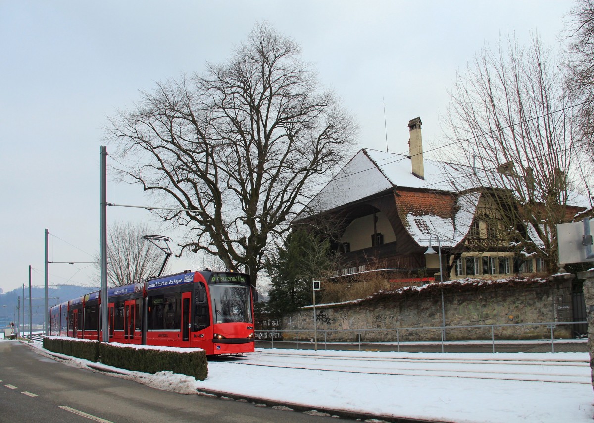 Berner Strassenbahnwagen 765 (Combino) auf der RBS (Regionalverkehr Bern-Solothurn) vor dem Gebudekomplex des Schlosses Muri, 21.Januar 2016. 