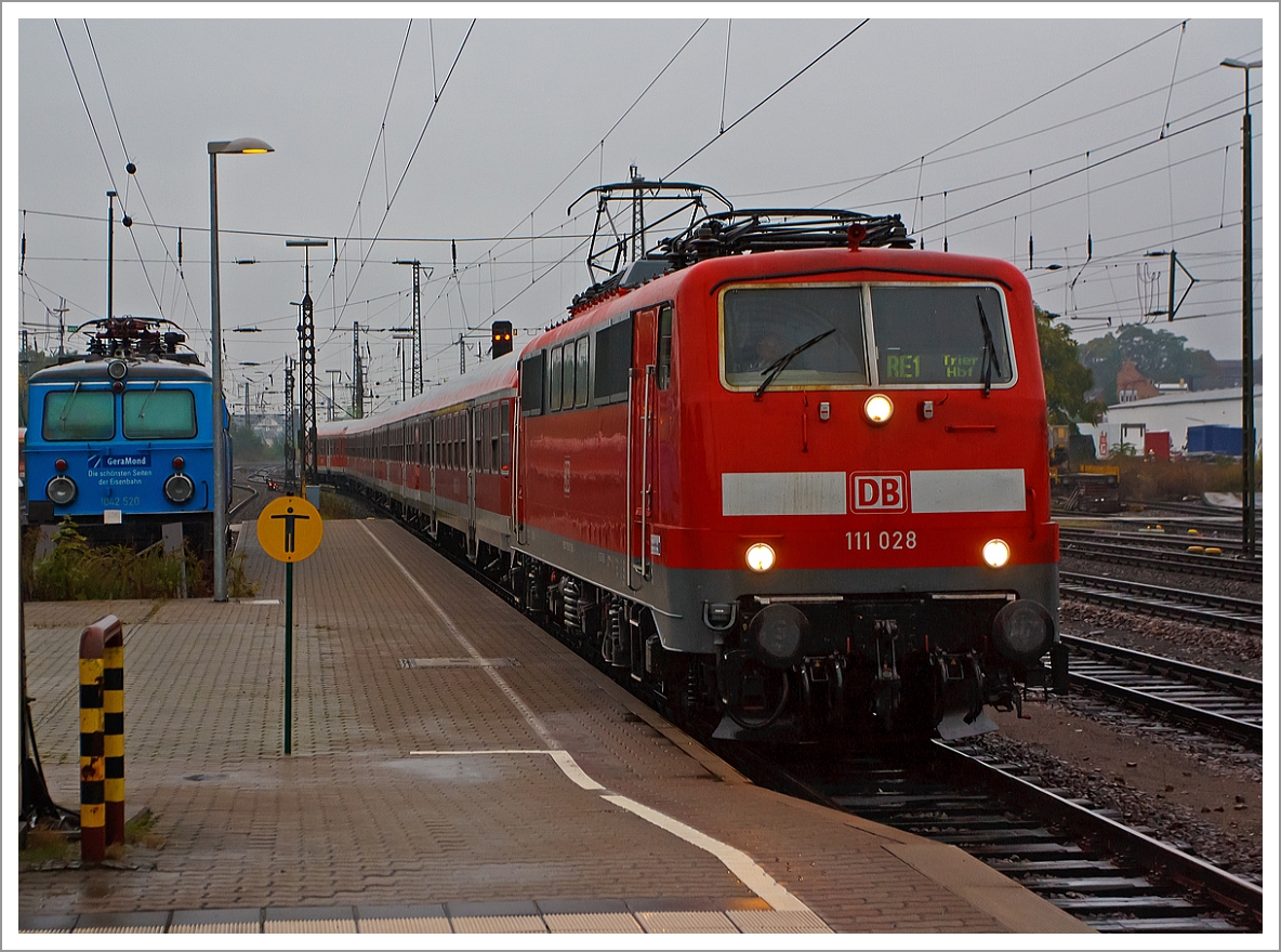 Das Ergebnis von dem Regenfotograf....
Die 111 028 mit dem RE 1   Mosel-Saar-Express    Koblenz  – Wittlich  – Trier fhrt am 05.10.2013 in den Hbf Trier ein, fr diesen Umlauf ist es die Endstation, ansonsten fhrt der RE 1 via Saarlouis und Vlklingen  bis Saarbrcken