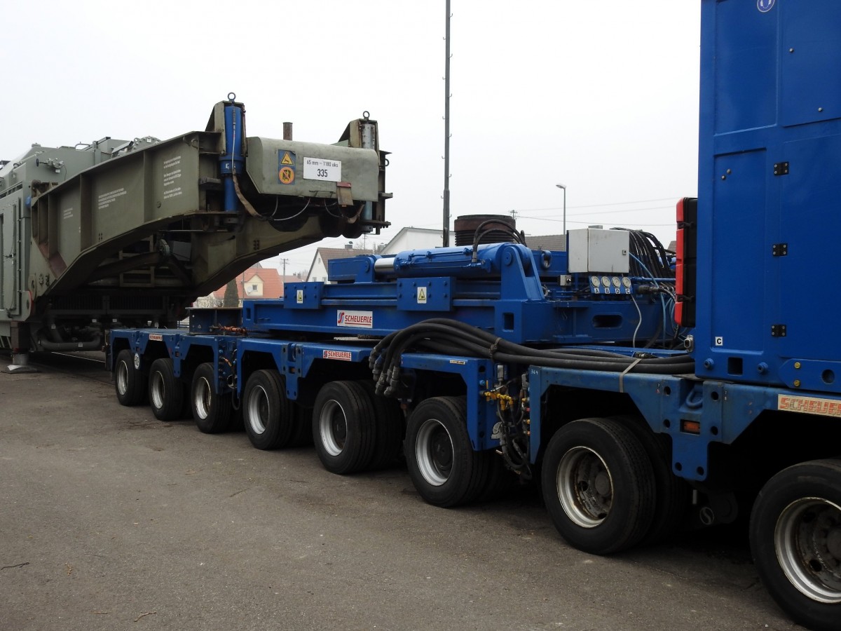 Das Scheuerle Power Pack Unit(PPU) Z 500 DE, Baujahr 2011, schiebt sich unter den Schnabel des 84 80 D AMPR 996 0 003-5, Baujahr 1961, von Ampiron mit Siemens-Transformator f�r Max.-Dauerleistung von 333,33 MVA. Die Waggonh�lfte ist auf Stempel, links unten im Bild zu sehen, aufgest�tzt, V�hringen am 09.03.2016.
