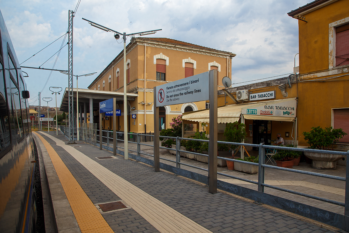 Der Bahnhof Lentini/Sizilien (italienisch Stazione di Lentini/Sicilia) bei km 154,4 an der Bahnstrecke Messina–Syrakus (RFI 152) am 19 Juli 2022.

Der Bahnhof Lentini wurde im Rahmen des Eisenbahnbauprojekts der Gesellschaft Vittorio Emanuele errichtet, welches von der Societ per le strade ferrate della Sicilia (Sizilianischen Eisenbahngesellschaft) fortgefhrt wurde. Er war Teil des Projekts, die Gegend um Syrakus (Siracusa) per Eisenbahn mit der Stadt und dem Hafen von Catania zu verbinden und landwirtschaftliche Produkte, insbesondere Zitrusfrchte, aus der Gegend um Lentini und der Ebene von Catania zu den Mrkten zu transportieren. Der Bahnhof wurde am nrdlichen Stadtrand von Lentini, in der Nhe des Lentini-Sees, errichtet und am 1. Juli 1869 eingeweiht, zeitgleich mit der Erffnung der Eisenbahnlinie Catania Centrale nach Lentini. Am 19. Januar 1871 wurde er mit der Erffnung des letzten 57,8 km langen Abschnitts bis zum Bahnhof Syrakus (Siracusa) auch mit Syrakus, im Sdosten von Sizilien, verbunden.

Neben den Regionalzge halten in dem Bahnhof auch Fernverkehrszge der Gattung Intercity (IC) und Intercity Notte (ICN). 

Ca. 4 km nrdlich in Lentini Diramazione zweigt zudem die Bahnstrecke (RFI 154) nach Gela ab.

Merkmale
Der Bahnhof besteht aus einem zweistckigen Gebude am sdlichen Ende des Gleiskomplexes. Das Bahnhofsgebude befindet sich westlich der Gleise. Der Bahnhof ist ein Haltepunkt fr Personenzge aller Kategorien.

Der Gleiskomplex umfasst das erste Durchgangsgleis, ein berholgleis und ein Vorranggleis fr den Personenverkehr sowie mehrere Gtergleise. Nur das erste Gleis verfgt ber einen Unterstand. Die verschiedenen Gter- und Abstellgleise befinden sich auf der Westseite des Bahnhofs. Frher fuhren viele Gterzge mit Zitrusfrchten vom Bahnhof Lentini ab. Seit Ende der 1980er Jahre ist der Verkehr deutlich zurckgegangen.

Am 15. Dezember 2019 weihte der Prsident der Region Sizilien den modernisierten Bahnhof ein. Insbesondere wurde eine Unterfhrung mit Rampen fr Behinderte und neue Bahnsteige errichtet. 

Quellen: Wikipedia (Italien) 
Stand: September 2025
