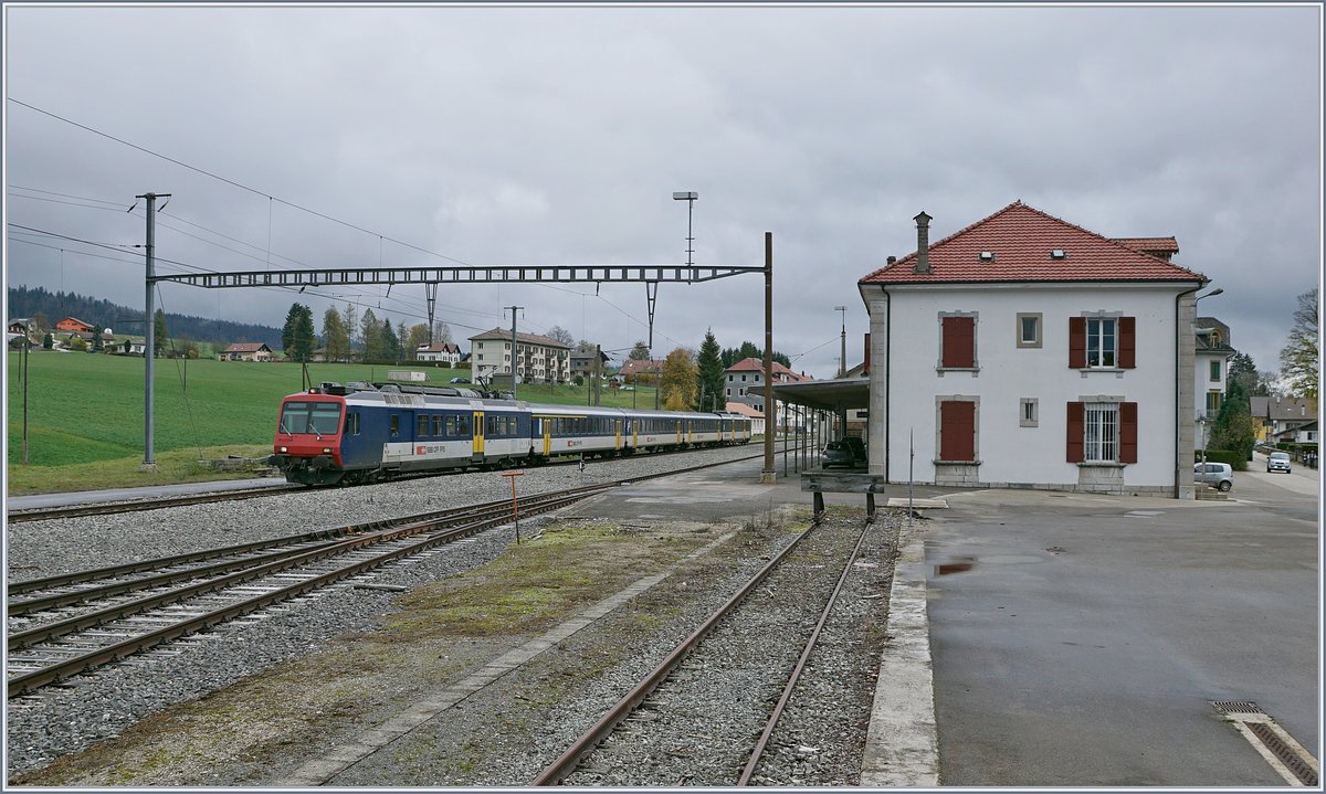 Der RE 18124 Neuchâtel (12:06) nach Frasne (13:06) bei der Durchfahrt in Les Verrières. Der Zug besteht aus folgenden Fahrzeugen: RBDe 560 004-2, AB 50 85 30-35 603-1, B 5085 20-35 600-9, B 85 20-35 602-5 und dem führenden Bt 50 85 29-35 952-5. Les Verrières, ein Fahrdienstlich bedienter Bahnhof mit Wartesaal und Billettschalter, letzterer reichlich an Prospekten bestückt aber geschlossen. Mit nur drei Zugspaaren, die ohne Halt den Bahnhof passieren, dürfte Les Verrière eine am wenigsten frequentierten Bahnhöfe der Schweiz sein.

29. Okt. 2019