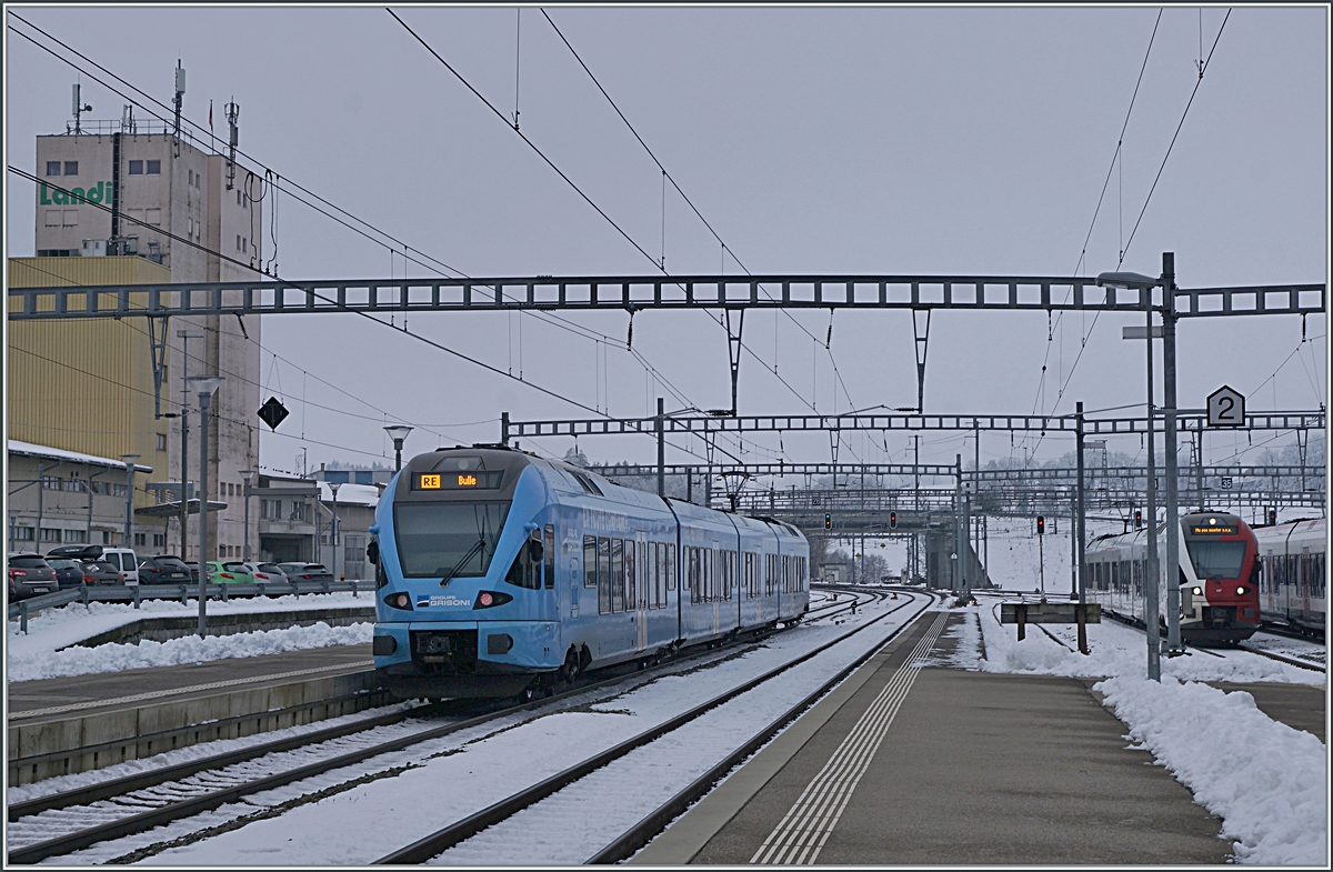 Der im sehr gef�lligen Werbeanstrich der  Groupe Grisoni  gehaltene TPF RABe 527 198 verl�sst Romont in Richtung Bulle. 

22. Dez. 2021 

