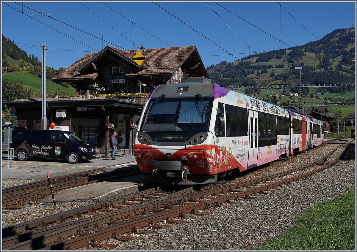 Der süss für die Nankai Electric Railway werbende MOB Pendelzug ABt 342 - Be 4/4 5002 - Bt 242 ergibt vor dem üppigen Blumenschmuck des Bahnhofs von Saanen ein sehr buntes Bild. 5. Okt. 2018