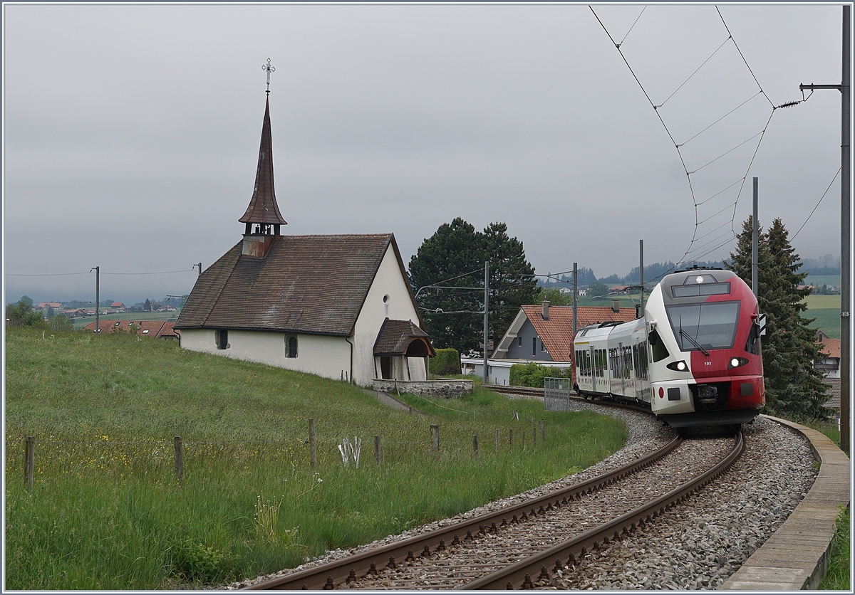 Der TPF RABe 527 193 als RE von Bulle nach Fribourg bei der  Chappel de Vaulruz  unter der herrlichen  windschiefen  Fahrleitung. 

12. Mai 2020 