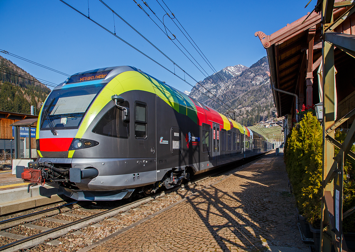 Der Trenitalia ETR 170 103, ein sechsteiliger Stadler FLIRT (MS für I / A) hat am 27.03.2022, als Regionalzug von Brenner/Brennero via Bozen/Bolzano nach Meran/Merano, den Bahnhof Gossensaß/Colle Isarco erreicht.

Diese sechsteiligen Elektrotriebzüge vom Typ Stadler FLIRT wurden für den grenzüberschreitenden Verkehr zwischen Italien und Österreich konzipiert. Die 160 km/h schnellen Züge werden auf den Linien Meran-Bozen-Brenner, Unterland Trento-Ala und Franzensfeste-Innichen-Lienz (Pustertal) eingesetzt. Die aktuelle Flotte besteht derzeit aus 25 FLIRTs. Sie sollen auch noch im Vinschgau (Meran-Mals), unter 25 kV 50 Hz, eingesetzt werden. Sie sind mit dem Zugsicherungssystem ETCS ausgestattet. Die Flachbautechnik ermöglicht den direkten Einstieg ohne Podest. Der klimatisierte Innenraum und das offene und transparente Design machen die Reise mit angenehm für die Passagiere. Ein modernes Informationssystem versorgt die Fahrgäste mit allen notwendigen Informationen, sie sind zudem mit WLAN ausgestattet.

TECHNISCHE DATEN:
Bezeichnungen: ETR 170 (6-Teiler)
Spurweite:  1.435 mm (Normalspur)
Achsformel: Bo’ 2’2’2’2’2’ Bo’
Länge über Kupplung:106.578 mm 
Fahrzeugbreite: 2.800 mm
Fahrzeughöhe: 4.150 mm
Achsabstand in den Drehgestellen: 2.700 mm
Treibraddurchmesser: 860 mm (neu)
Laufraddurchmesser: 750 mm (neu)
Dauerleistung am Rad: 2.000 kW
Maximale Leistung am Rad: 2.600 kW
Stromsysteme: 15kV/16,7Hz; 25kV/50Hz; 3kV DC 
Anfahrzugkraft (bis 47 km/h):  200 kN
Höchstgeschwindigkeit: 160 km/h
Beschleunigung:  1,0 m/s²
Anzahl der Türen je Längsseite: 10
Breite der Türen: 1.320 mm
Maximale Sitzplätze: 258