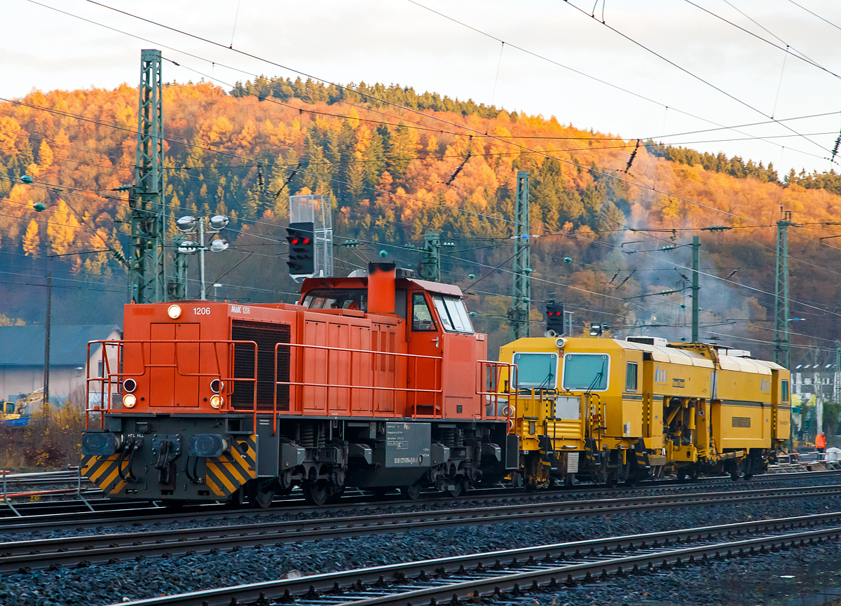 Die 275 870-4 (92 80 1275 870-4 D-BUVL) eine Vossloh MaK G 1206 Mietlok der B & V Leipzig GmbH rauscht mit der P & T Universalstopfmaschine Unimat 08 - 275 3S Y (Schweres Nebenfahrzeug Nr. 97 43 41 523 17 - 9) der DGU (Deutsche Gleisbau Union) am Haken am 18.11.2016 durch Betzdorf/Sieg in Richtung Kln.