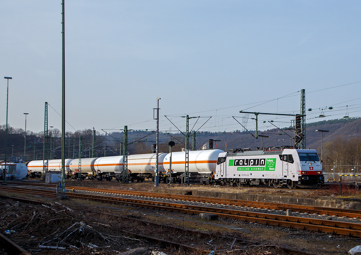 Die an die Cargologic AG (Kloten) vermieteten und bei der BLS Cargo AG eingestellten 186 910  (91 83 2186 910-2 I-BLSC) der AKIEM SAS, fährt am 03.03.2021 mit einem Kesselwagenzug durch Betzdorf (Sieg) in Richtung Siegen. Die Lok macht Werbung für die Rollende Landstraße (RoLa) Freiburg i.B. - Novara der RAlpin AG.

Die TRAXX F140 MS wurde 2008 von Bombardier in Kassel unter der Fabriknummer 3437 gebaut und hat die Zulassungen für Deutschland, Österreich, Schweiz und Italien. Ursprünglicher Eigentümer war das Leasingunternehmen CBRail S.à r.l., ab 2013 dann Macquarie European Rail Limited (Luxembourg) und nun die AKIEM SAS, die das Leasinggeschäft für Schienenfahrzeuge der Macquarie Europeto Rail im April 2020 erworben hat.

Die Station (Mieter) der TRAXX waren u.a.:
Geliefert an  CBRail S.à r.l. (Luxembourg)  als E 186 910, eingestellt von Bombardier Transportation Kassel unter NVR-Nummer 91 80 6186 910-6 D-BTK und vermietet an Linea S.p.A., Pozzolo Formigaro (Italien)
2012 Rail Cargo Italia S.r.l..
2014 vermietet an Crossrail AG (91 83 2186 910-2 I-XRAIL)
2017  vermietet an SBB Cargo International AG
Seit 2018 Cargologic AG, Kloten (ehemals Crossrail)