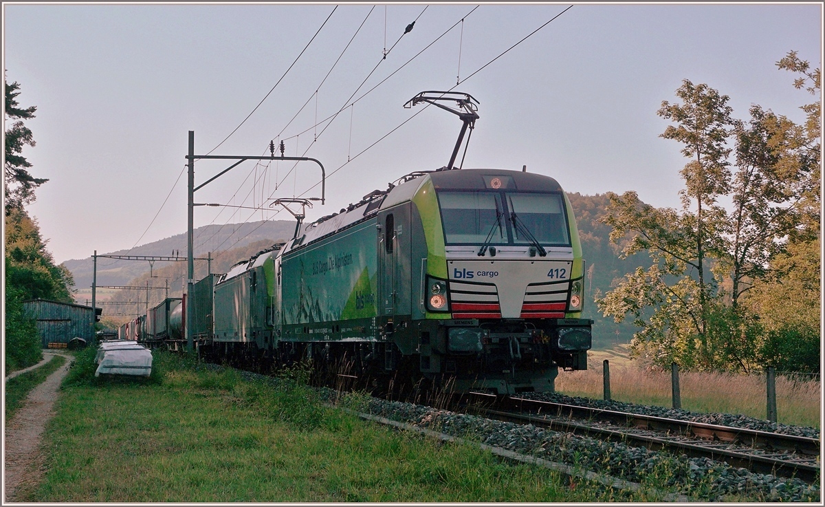 Die BLS Re 475 412 und eine weitere fahren im Schatten mit einem via Alte Hauensteinlinie umgeleiteten Güterzug Richtung Sissach. Der Zug fährt gerade durch den Bahnhof Sommerau und wird in Kürze eine Stelle erreichen die sich  Gotthard  nennt.
18. Juli 2018