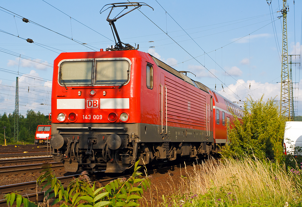 
Die DB 143 009-9, ex DR 243 009-8, schiebt die RB 27   Rhein-Erft-Bahn    (Mnchengladbach - Kln - Bonn-Beuel - Neuwied - Koblenz Hbf) durch Koblenz-Ltzel in Richtung Koblenz Hbf.

Die Lok wurde 1984 bei LEW (VEB Lokomotivbau Elektrotechnische Werke Hans Beimler Hennigsdorf) unter der Fabriknummer 18232 gebaut und als DR 243 009-8 an die Deutsche Reichsbahn geliefert, 1992 erfolgte die Umzeichnung in DR 143 009-9 und zum 01.01.1994 in DB 143 009-9. 

Ein Umbau (Einbau Notbremsberbrckung (NB) und elektropneumatischer Bremse (ep) erfolgte 2006 und 2012 die Hochrstung auf NB 2004.
Die Notbremsberbrckung (NB) dient bei Personenzgen dazu, den Zug trotz bettigter Notbremse weiterfahren zu lassen und erst an einem besser geeigneten Ort zum Stillstand zu bringen. Grund fr ihre Einfhrung war, dass das Halten eines brennenden Zuges in einem Tunnel zu verheerenden Folgen fhren kann, aber auch, dass ein Zug, der an einem schwer zugnglichen Punkt zum Stehen kommt, die Bergung erschwert. Die Notbremsberbrckung darf vom Triebfahrzeugfhrer nur in besonders gekennzeichneten Streckenabschnitten angewandt werden.

Bei der NB 2004 fhrt die Bettigung einer Notbremse allerdings zunchst nur zu einer optischen und akustischen Meldung im Fhrerstand. Der Triebfahrzeugfhrer muss diese Meldung entweder durch einen berbrckungsbefehl oder durch eine Schnellbremsung besttigen. Andernfalls wird die Notbremsung nach kurzer Zeit selbstttig wirksam.

Die Lok trgt seit 2007 die NVR-Nummer  91 80 6143 009-9 D-DB und die EBA-Nummer  EBA 01C17A 009   .