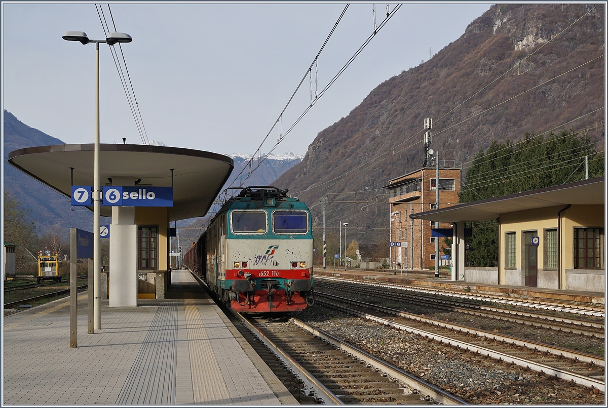 Die FS Treniatlia E 652 110 steht mit einem langen Hochbordwagenzug in Premosello-Chiovenda und wartet nicht wie ich erst vermutet die Kreuzung eines Gegenzuges ab, sondern die Streckenfreigabe Richtung Stresa, dies ist insbesondere interessant, da der Zug auf der  Novara  Strecke in Premosello-Chiovenda angekommen ist. 29. Nov. 2018