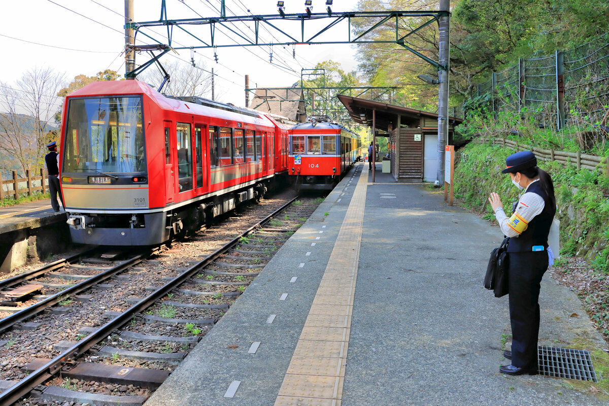 Die Hakone Tozan Tetsudô (Hakone Bergbahn, auch Hakone Tozan Densha – elektrische Hakone Bergbahn - genannt) bildet das Hauptglied einer Transportkette von der Stadt Odawara hinauf auf den 1040m hohen Grat von Ôwakudani hoch über einem imposanten Vulkantal voller brodelnder Dämpfe und Gase. Bis zum 6,1 km talaufwärts von Odawara entfernten Ort Hakone Yumoto – bekannt für seine heissen Quellen – weist die Strecke eine Spurweite von 1067mm auf und wird heute von der Odakyû Privatbahn mit direkten Zügen aus Tôkyô befahren. Zwischen Hakone Yumoto und dem Dorf Gôra (etwa 476 müM) verkehrt die sehr steile Hakone Bergbahn (Spurweite 1435 mm) in mehreren Stufen, d.h. sie wechselt dreimal die Fahrtrichtung. Von Gôra aus führt eine Standseilbahn in die Höhe, und schliesslich steigt man in eine spektakuläre Luftseilbahn, um über das Vulkantal hinweg den Grat von Ôwakudani zu erreichen. Im Bild kreuzen sich zwei Züge in Miyanoshita, links der neue Triebwagen 3101 von 2017, rechts der Originaltriebwagen 104 von 1919 (um 1950 Wagenkasten-Erneuerung). 12.April 2022 