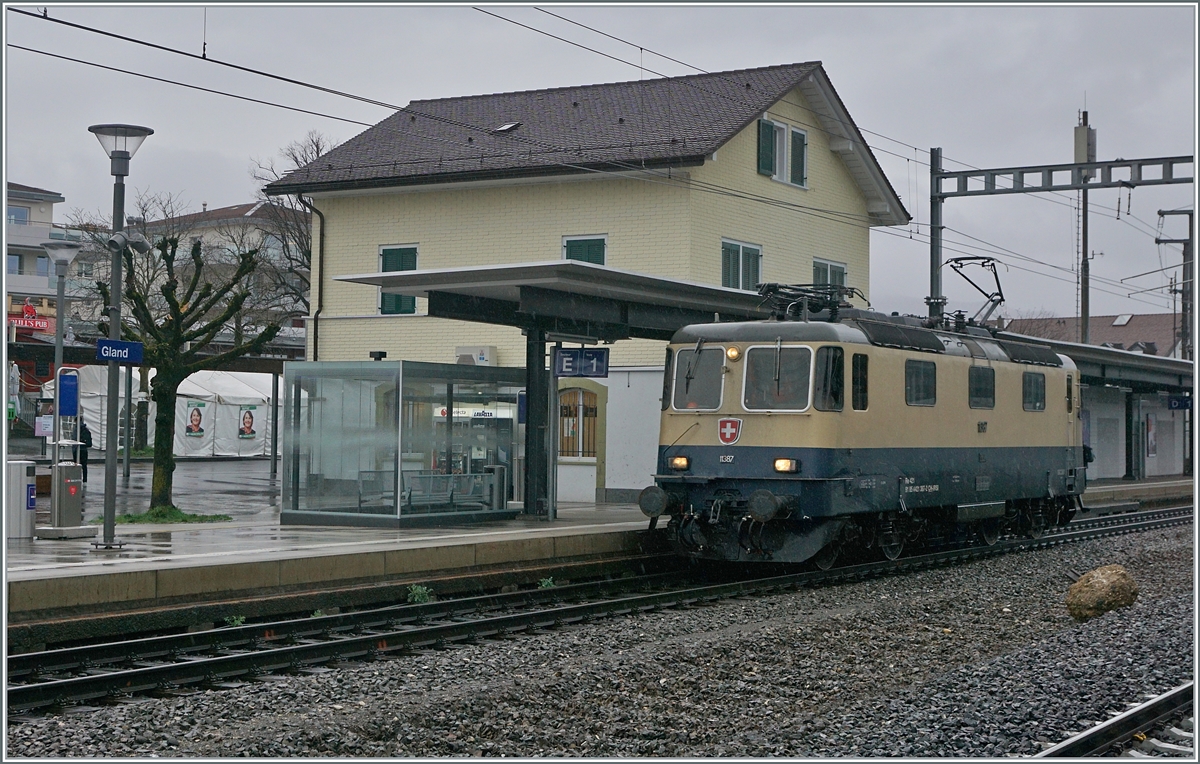 Die IRSI  Reingold  Re 4/4 11387 erreicht Gland. Die Die IRSI/IGE Re 4/4 II 11387 (Re 421 387-2) ersetzt die zur Zeit in der Revision in Bellinzona weilende BAM MBC Re 420 506.

22. Feb. 2024